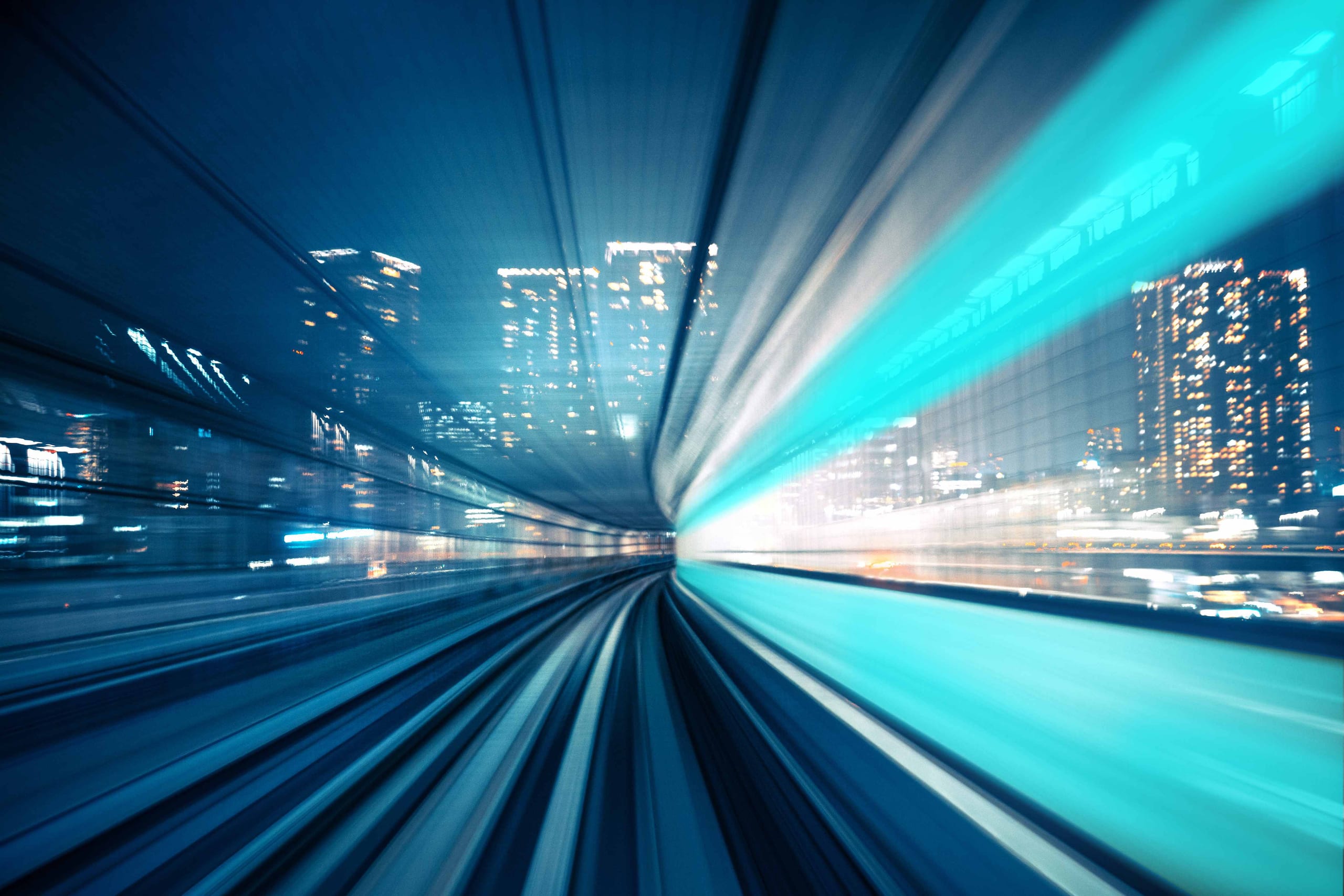 Monorail track rushing through a nighttime cityscape with teal light streaks