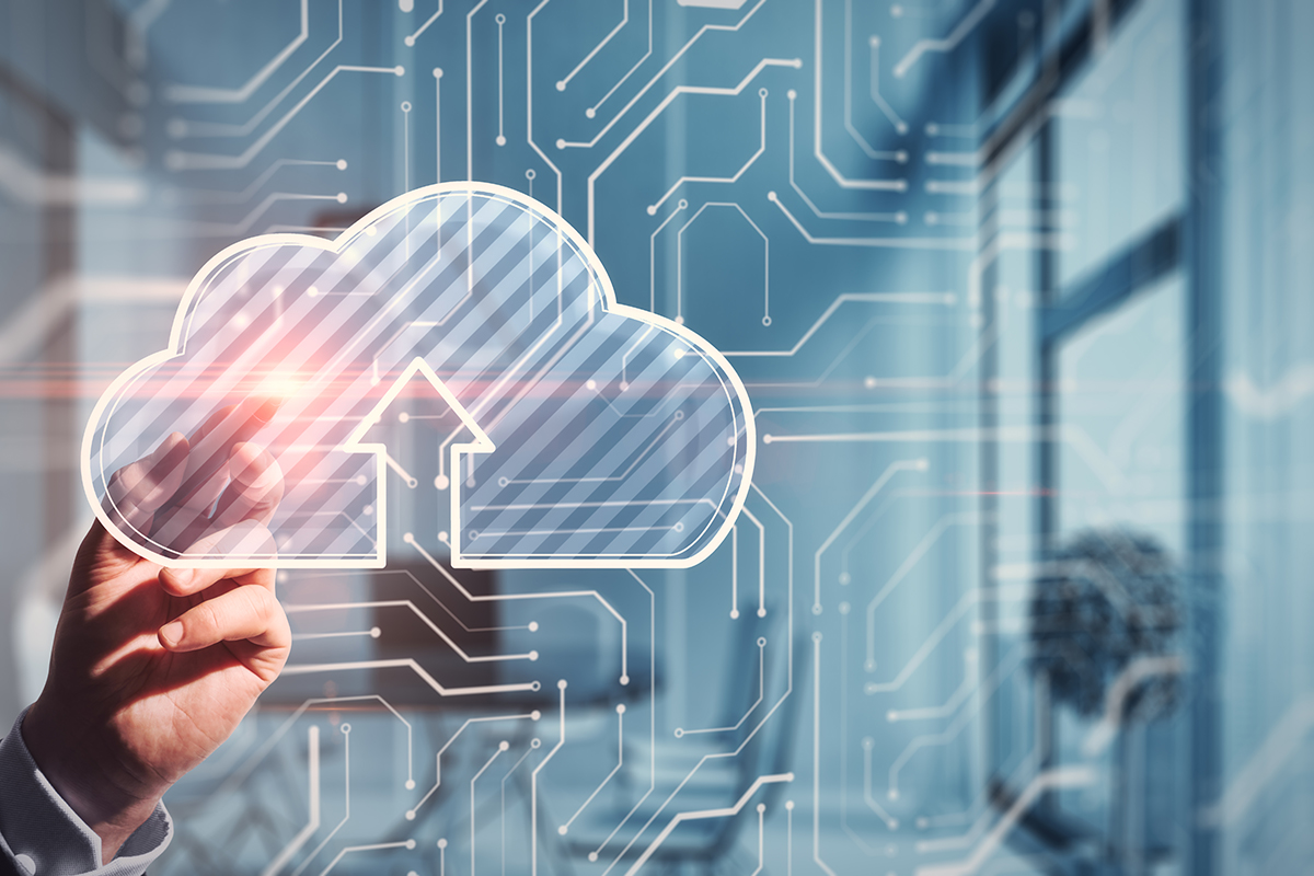 Hand holding a glowing translucent cloud upload icon against a blue circuit board background